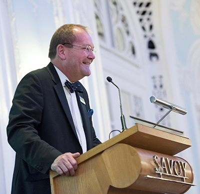 Simon speaking at an event at the Savoy