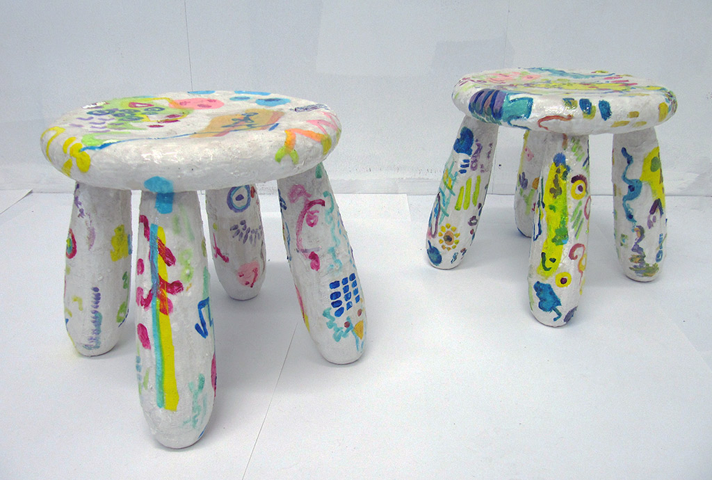In the classroom. Blanket fort detail: Pair of plastic stools. Jan 2022. Plastic stools, Modroc, Acrylic paint. 29 cm x 36 cm x 36 cm each