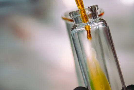 Pipette dropping liquid into glass bottle