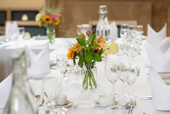 Tables laid for dining, with linens and flowers 