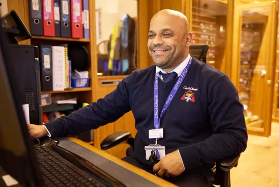 A porter at the computer in the Christ Church Porters' Lodge