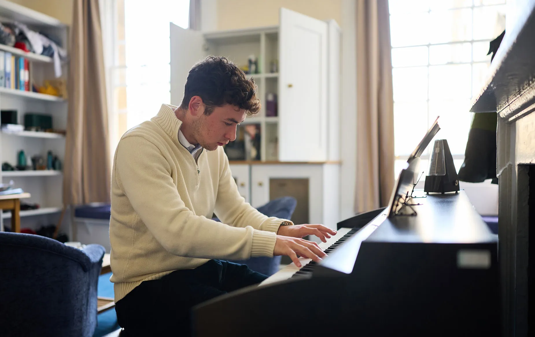 A music student using the piano provided in his accommodation