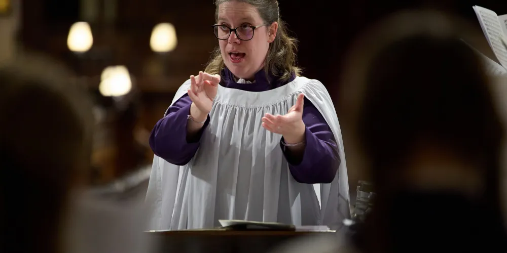 Helen Smee, wearing liturgical clothing, directs Frideswide Voices