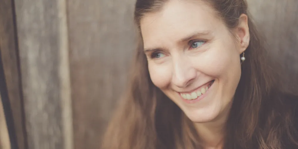 Photo of Fiona Benson, a smiling woman with long brown hair.