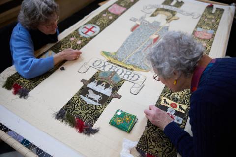 Two members of the Cathedral Embroidery Centre add finishing touches to a new cope