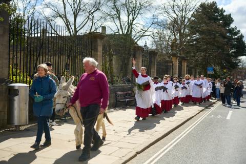 Monty the donkey leads Christ church Cathedral Choir down st aldates during their Palm Sunday procession