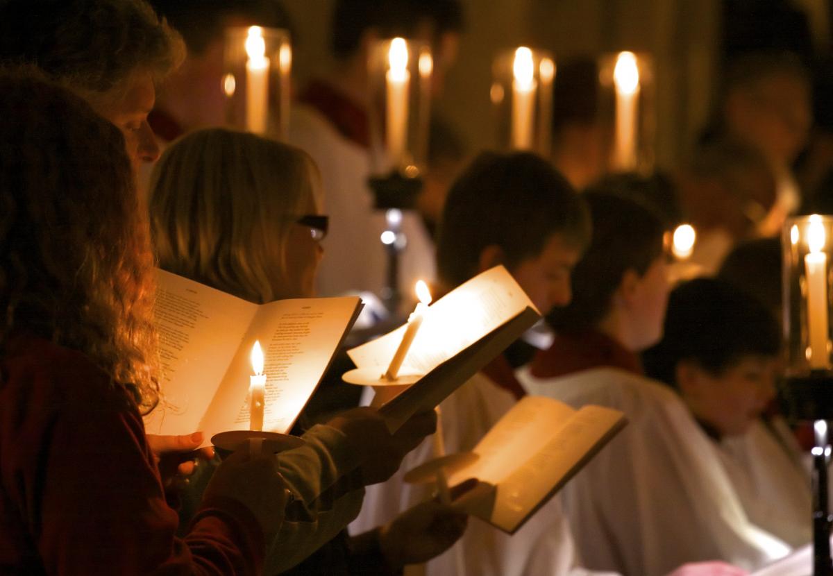 The congregastion hold candles at a Cathedral carol service while singing a hymn