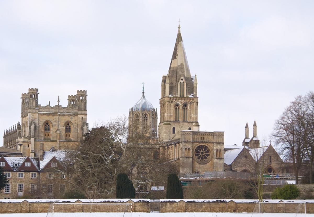 The Christ Church site viewed from across the meadows, with snow on the ground and rooftops.