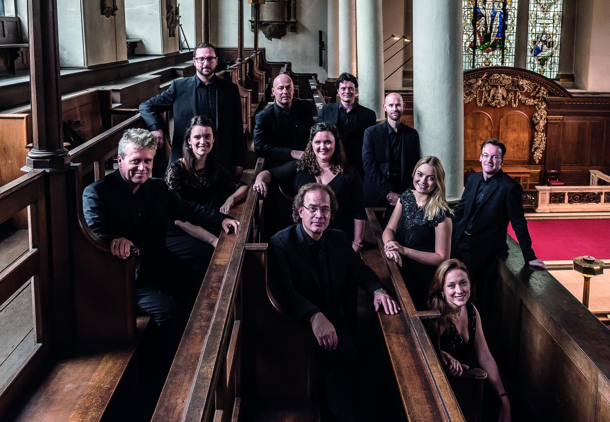 The Alamire choir, sitting and smiling in church pews.
