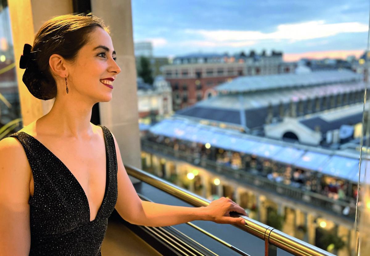 Smiling pianist Judith Engel looks out over a european city.
