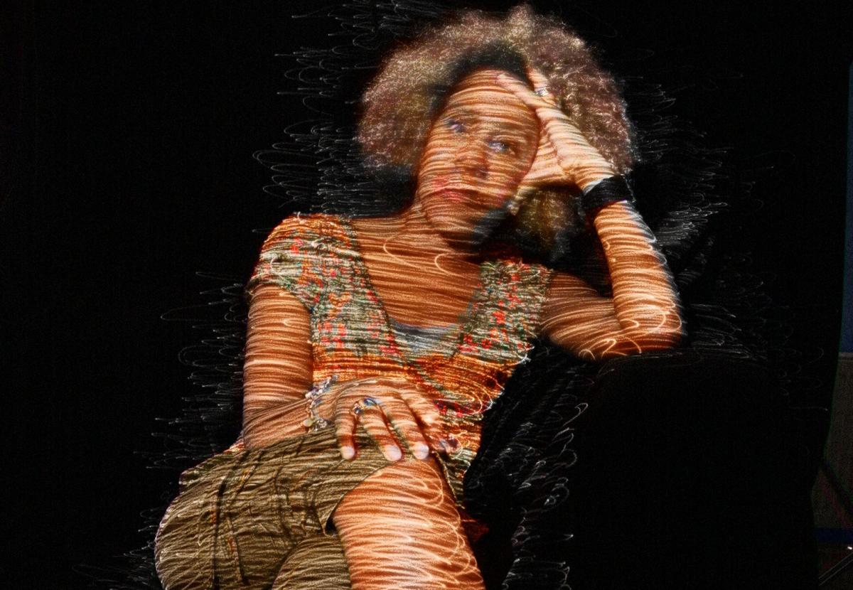 Errollyn Wallen, with soundwave like lines of light projected onto her.