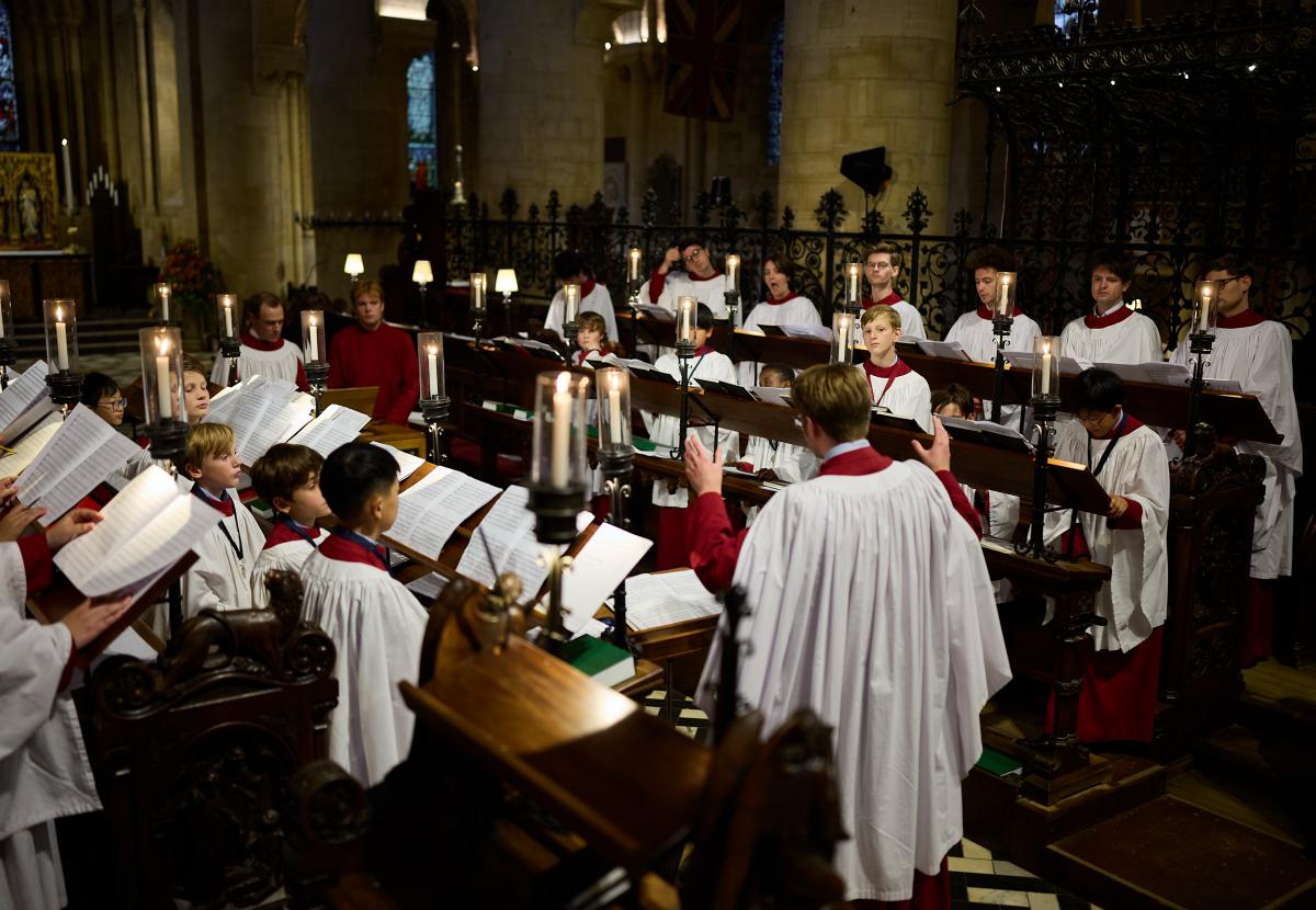 Peter Holder conducts the 2025-26 Cathedral CHoir from the choir stalls, all in robes