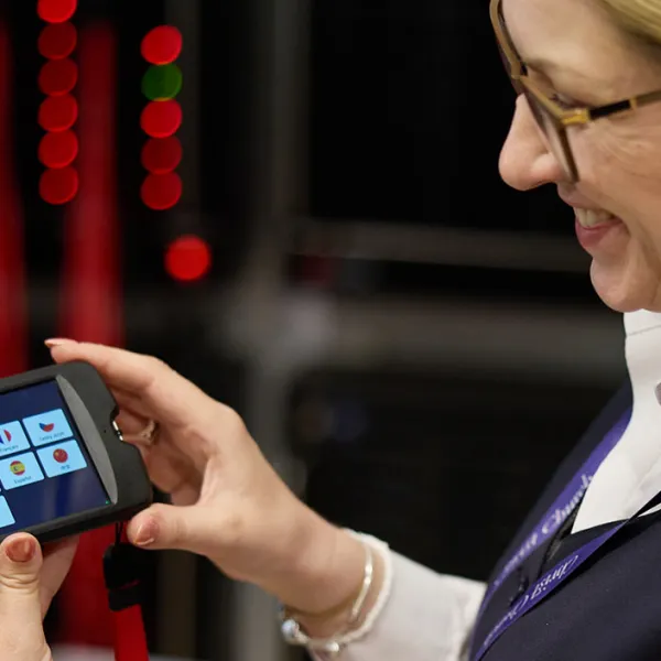 Custodian demonstrating a multimedia guide to a visitor