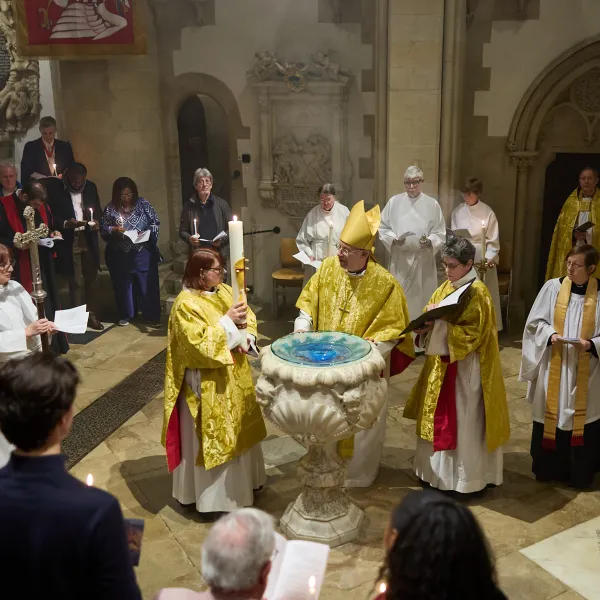 The Paschal easter candle is blessed by the Bishop of Oxford, who is around the font with the Dean and the Precentor, all in liturgical robes and golden copes. Around them are the congregation.