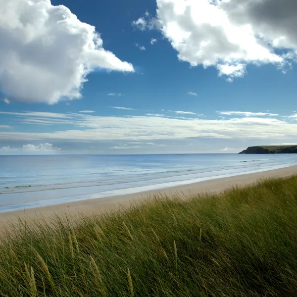 An empty beach on the Isle of Lewis under blue skies.