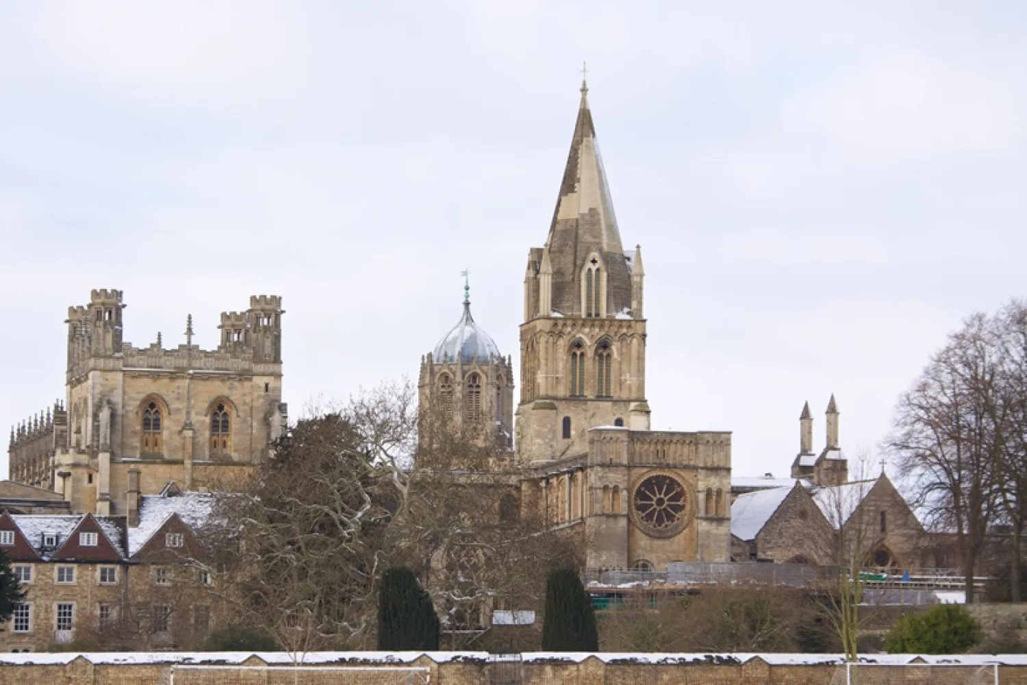 The Christ Church site viewed from across the meadows, with snow on the ground and rooftops.