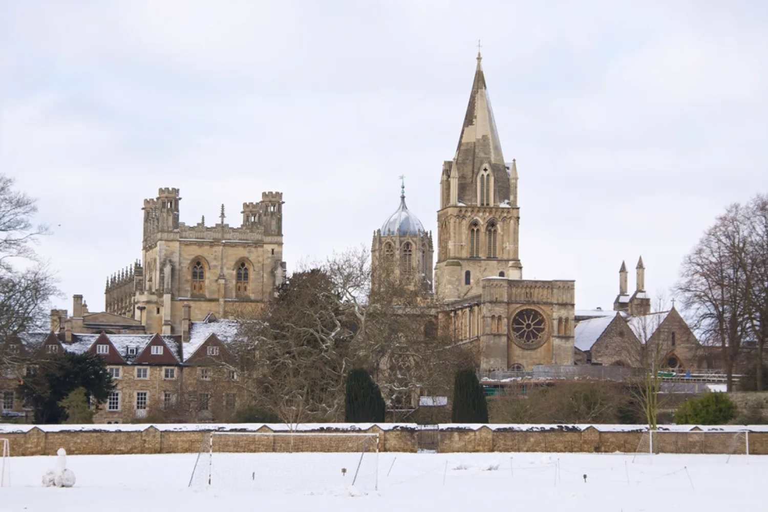 The Christ Church site viewed from across the meadows, with snow on the ground and rooftops.