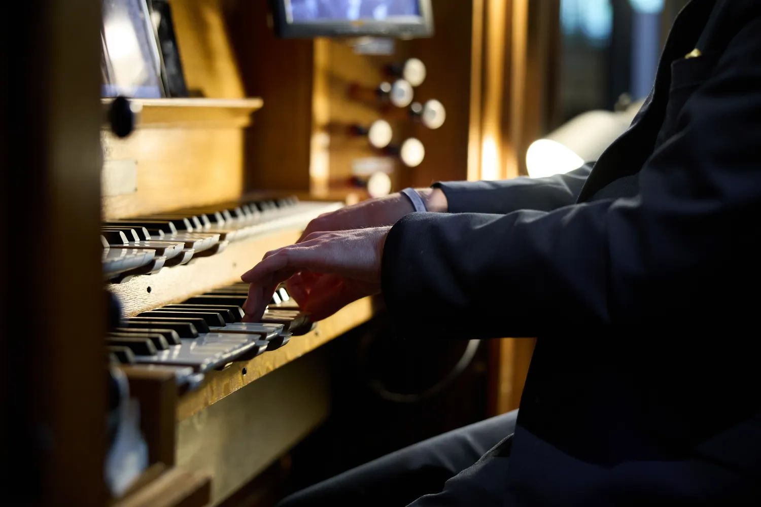 The hands of an organist are visible playing at Christ Church