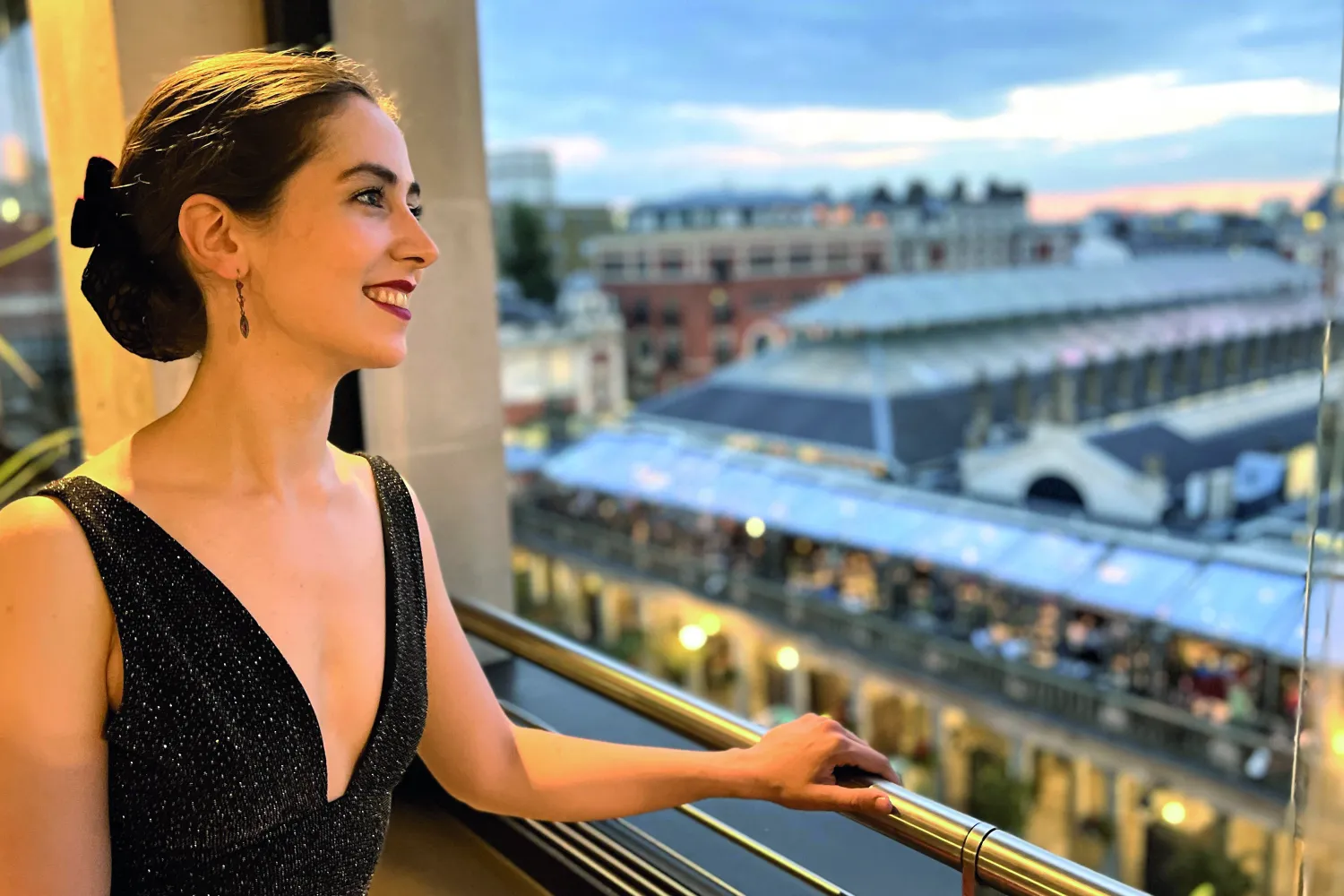 Smiling pianist Judith Engel looks out over a european city.