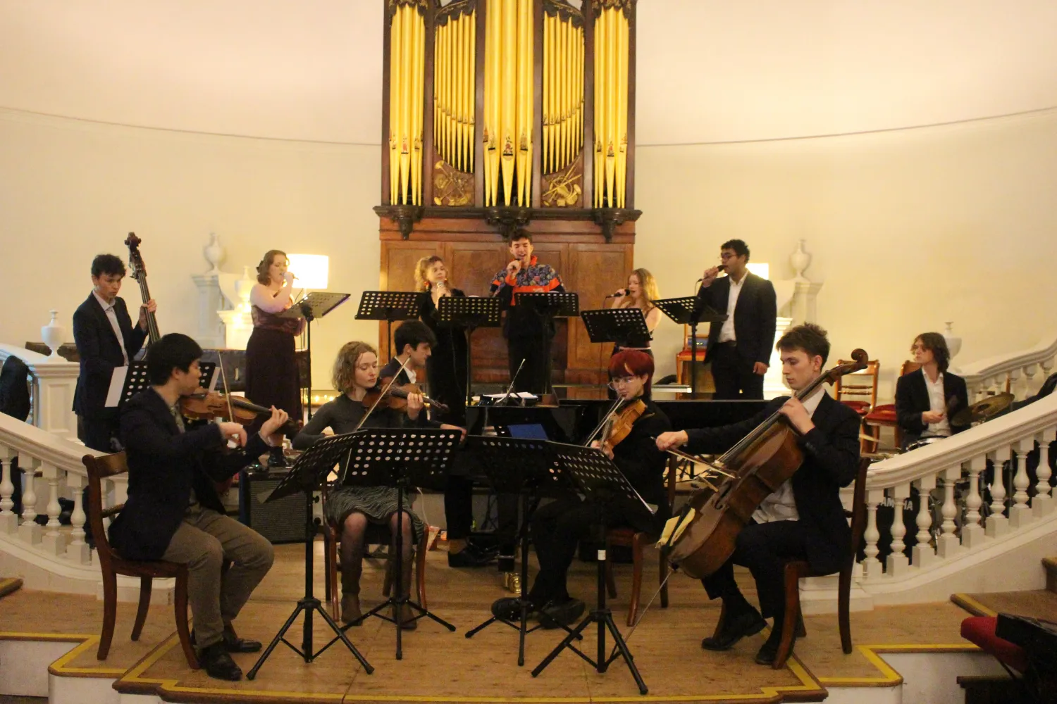 Little kitchen, a band made of a string quartet, bassist, drummer and five singers, perform in the grand setting of Hollywell Music room in front of the organ.