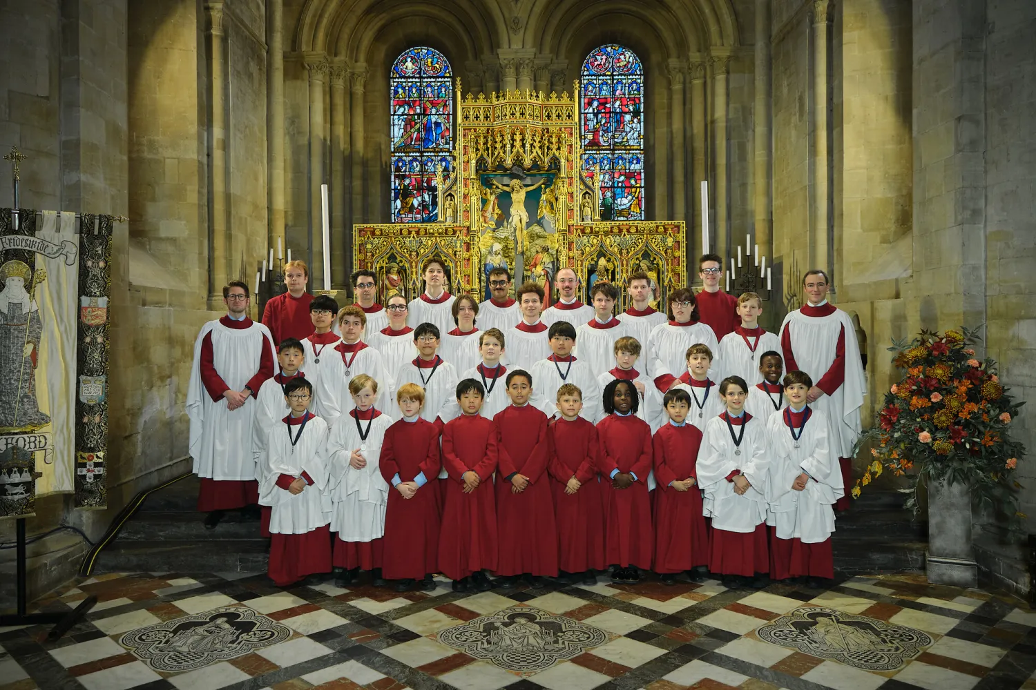 The 2025/26 cathedral choir, group portrait in choir robes by the high altar in the cathedral