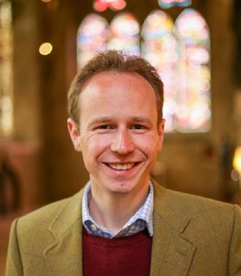Matthew Dickins, with the Latin Chapel and Burn Jones window of the Cathedral behind