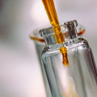Pipette dropping liquid into glass bottle