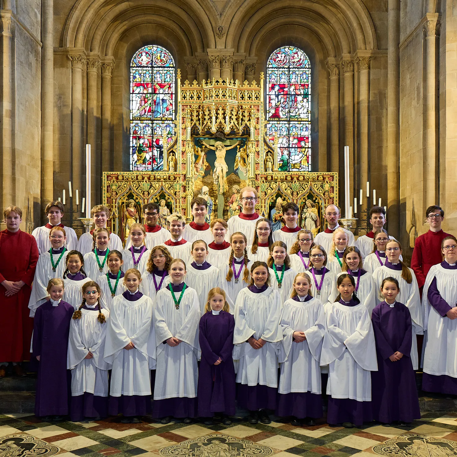 Frideswide Voices, the clerks and organ scholars, arranged in the choir robes in front of the cathedral altar.