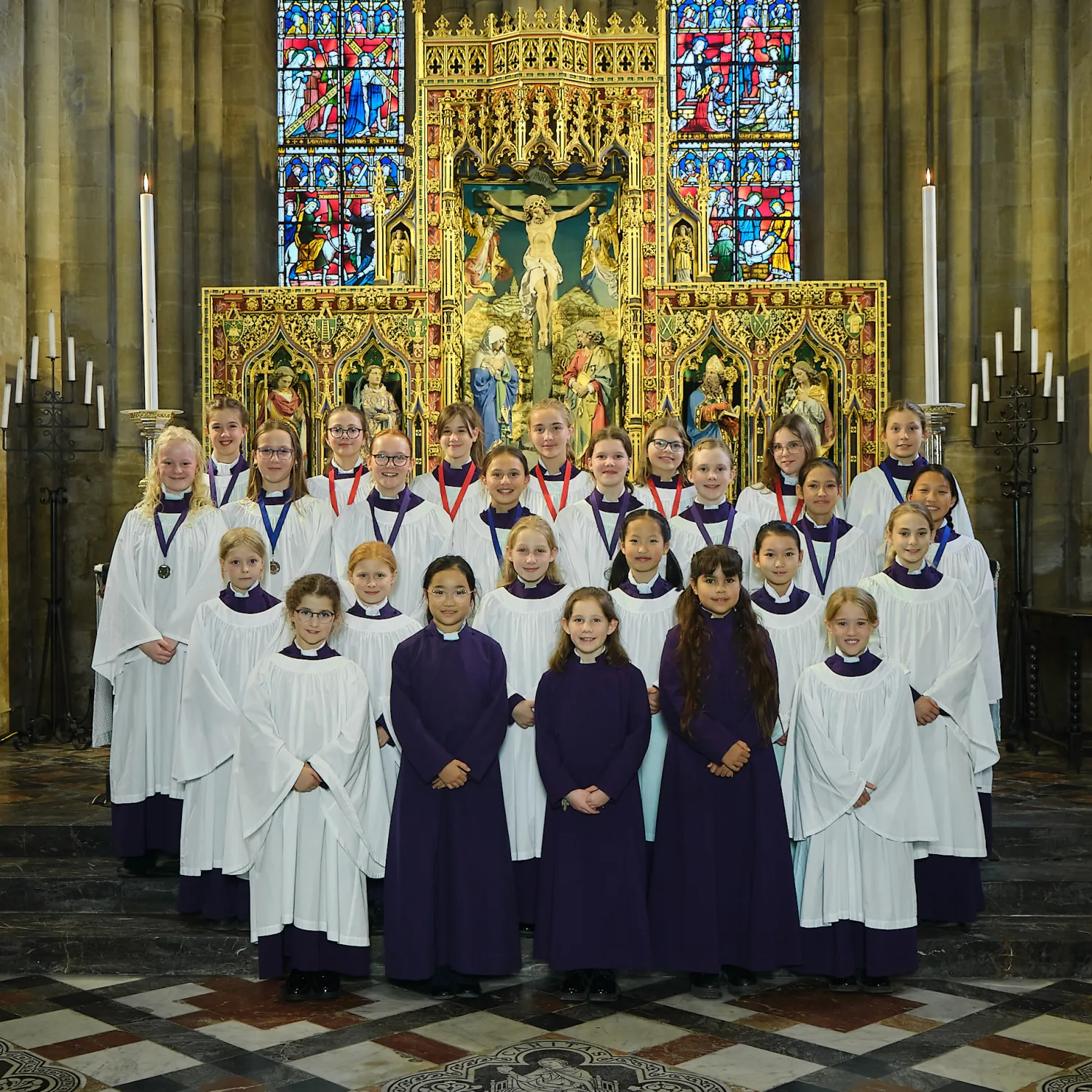 Frideswide Voices choristers in their choir dress gathered by the high altar of Christ Church Cathedral